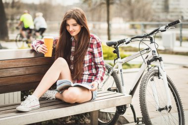 Genç kadın bir bisiklet gezisi kahve içme