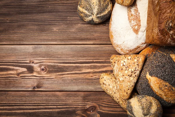 Bread assortment on wooden surface — Stock Photo, Image