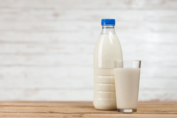 Milchflasche auf Holztisch — Stockfoto