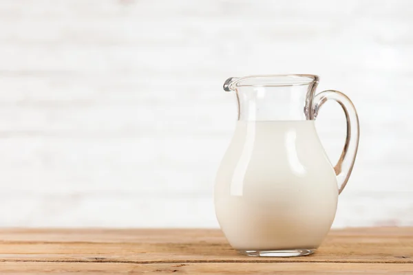 Tarro de leche sobre mesa de madera —  Fotos de Stock