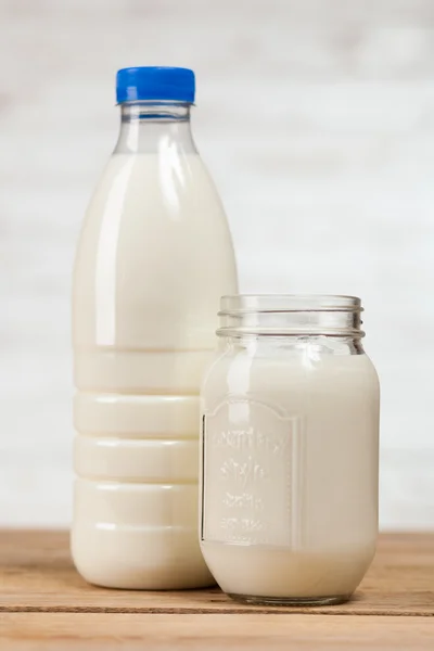 Botella de leche sobre mesa de madera — Foto de Stock