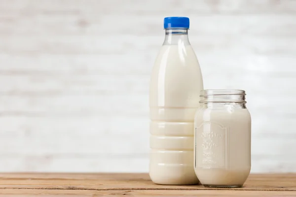 Ahşap masa üzerinde süt şişesi — Stok fotoğraf