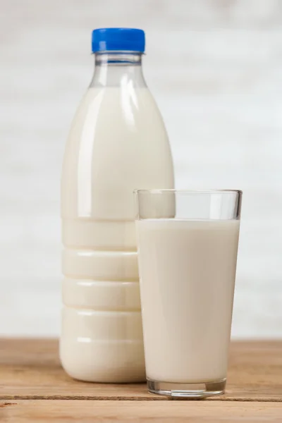 Botella de leche sobre mesa de madera — Foto de Stock