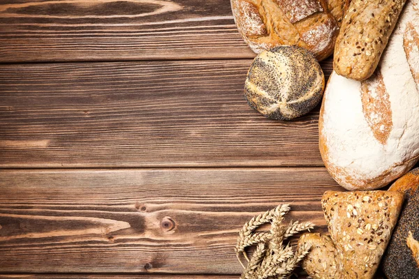 Sortiment de pâine pe suprafața de lemn — Fotografie, imagine de stoc