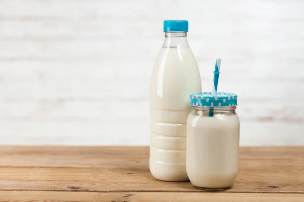 Botella de leche sobre mesa de madera — Foto de Stock