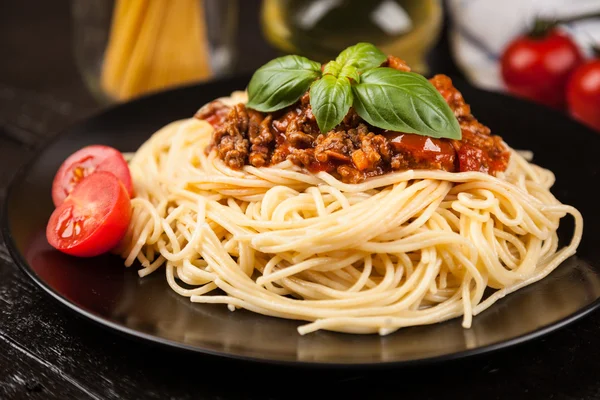 Espaguetis boloñeses sobre fondo oscuro — Foto de Stock