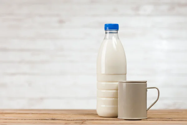 Milk bottle on wooden table — Stock Photo, Image