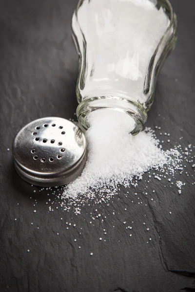 Salt shaker on slate board — Stock Photo, Image