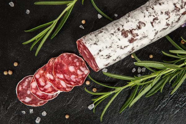 Salami na ciemnym tle — Zdjęcie stockowe