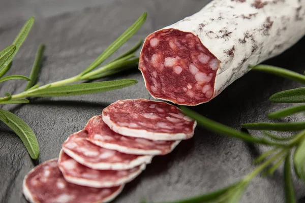 Salami op donkere achtergrond — Stockfoto