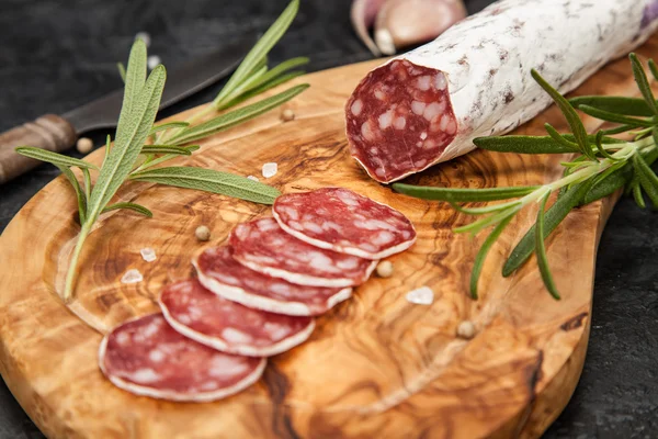 Salami na ciemnym tle — Zdjęcie stockowe