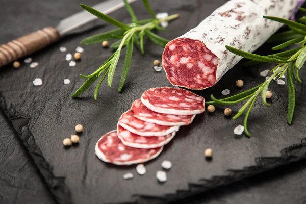 Salami na ciemnym tle — Zdjęcie stockowe