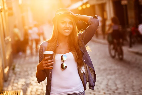 Jonge stijlvolle vrouw in een stad straat — Stockfoto