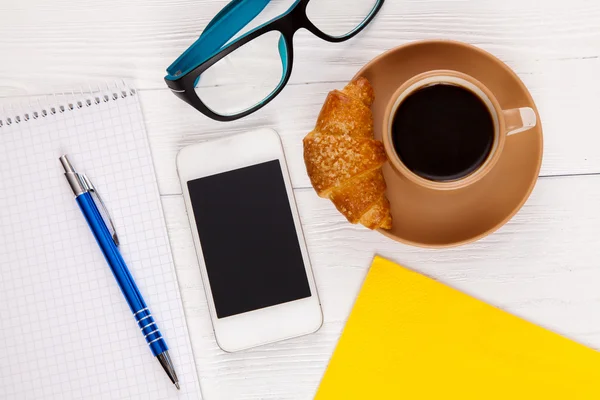 Café avec croissant sur une table de travail — Photo