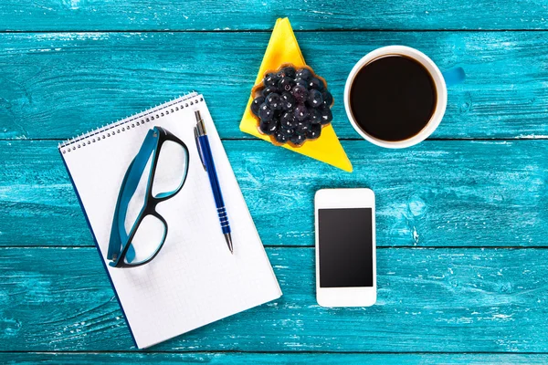 Café e bloco de notas em uma mesa em um café — Fotografia de Stock