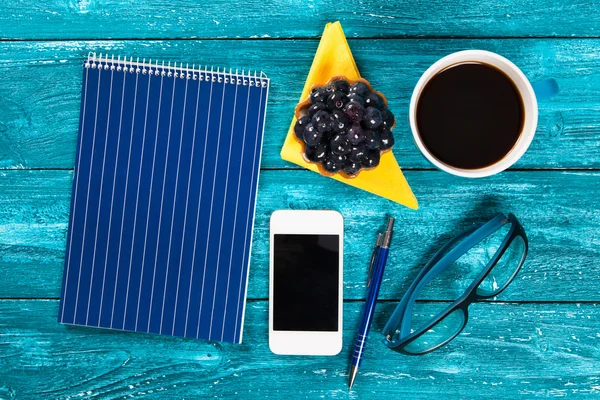 Coffee and notepad on a table in a cafe — Stock Photo, Image