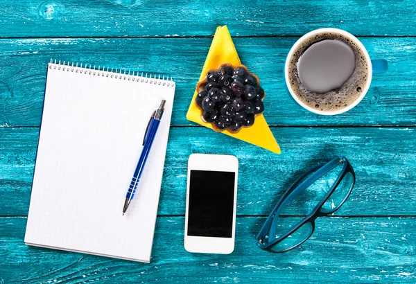 Coffee and notepad on a table in a cafe — Stock Photo, Image