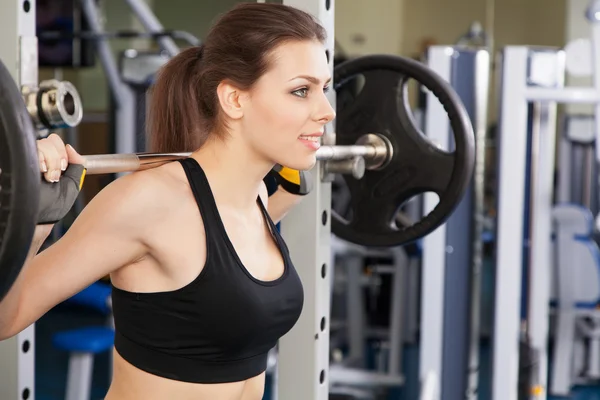 Joven mujer delgada haciendo ejercicio en un gimnasio —  Fotos de Stock