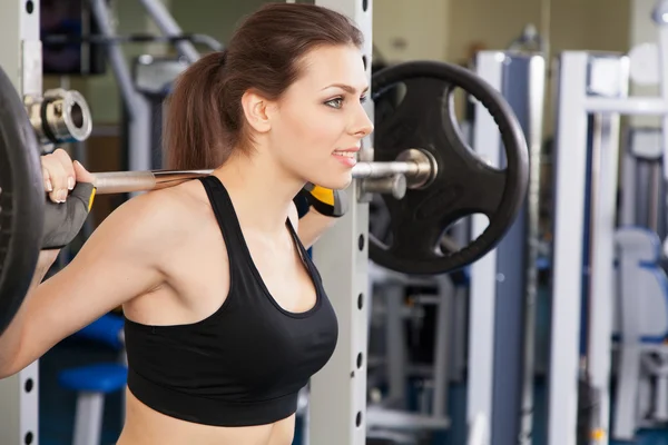 Joven mujer delgada haciendo ejercicio en un gimnasio — Foto de Stock