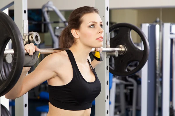 Giovane donna magra che si esercita in una palestra — Foto Stock