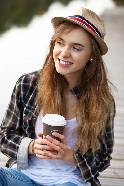 Young beautiful girl sitting on a pier — Stock Photo, Image