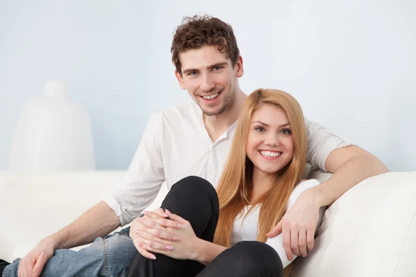 Jonge mooie paar op een sofa thuis — Stockfoto