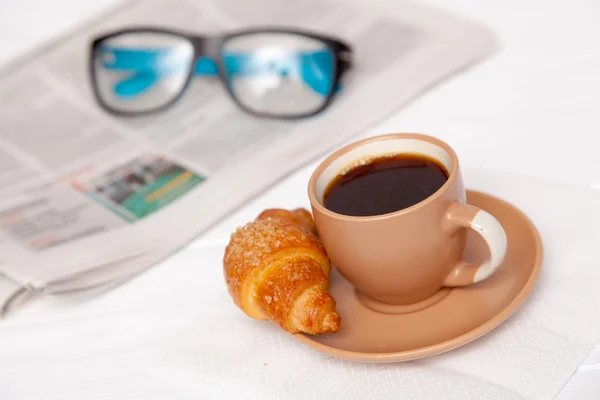 Kaffe och croissant på ett arbetsbord — Stockfoto