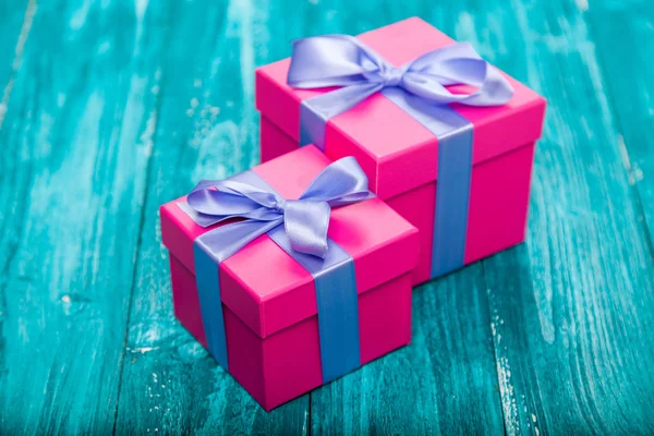 Cajas de regalo rosadas en madera azul —  Fotos de Stock