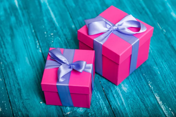 Różowy pudełka na niebieski drewno — Zdjęcie stockowe