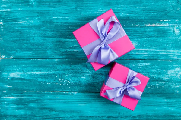 Růžový dárkové boxy na modré dřevo — Stock fotografie