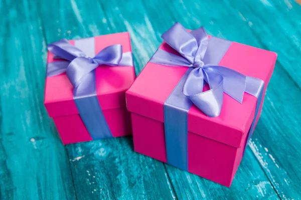 Rosa Geschenkboxen auf blauem Holz — Stockfoto