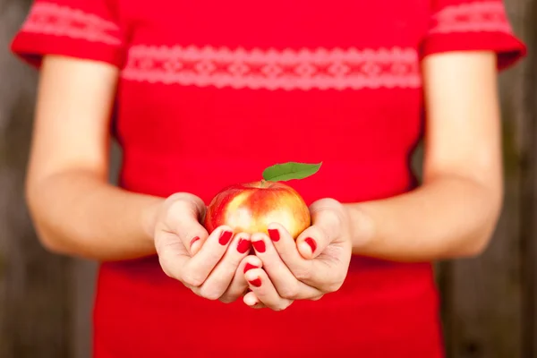 Weibliche Hände, die einen roten Apfel halten — Stockfoto