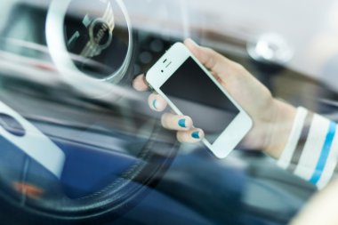 Wroclaw, Polonya - Ağustos 05, 2014: iphone 4 smartphone aygıtı tutan bir mini cooper arabada oturan genç bir kadın fotoğrafı