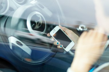 Wroclaw, Polonya - Ağustos 05, 2014: iphone 4 smartphone aygıtı tutan bir mini cooper arabada oturan genç bir kadın fotoğrafı