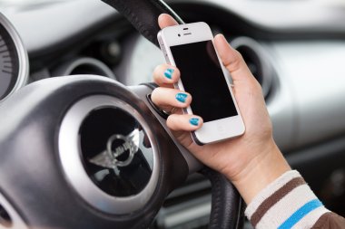 Wroclaw, Polonya - Ağustos 05, 2014: iphone 4 smartphone aygıtı tutan bir mini cooper arabada oturan genç bir kadın fotoğrafı