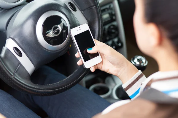 WROCLAW, POLONIA - 05 DE AGOSTO DE 2014: Foto de una joven sentada en un coche Mini Cooper con un teléfono inteligente iPhone 4 —  Fotos de Stock