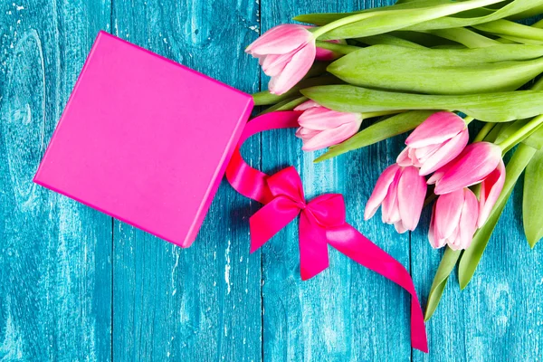 Beautiful pink tulips on blue wood background