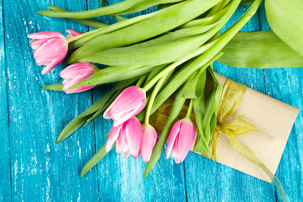 Beautiful pink tulips on blue wood background