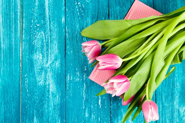 Beautiful pink tulips on blue wood background — Stock Photo, Image