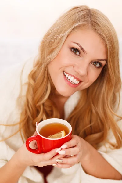 Jeune femme se relaxant au lit avec une tasse de café — Photo