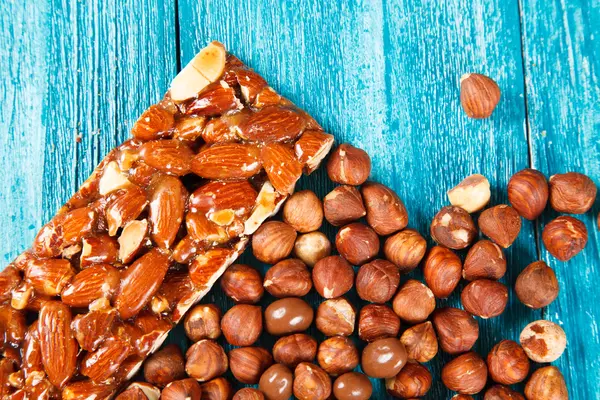 Nocciole e caramelle al cioccolato su fondo di legno blu — Foto Stock