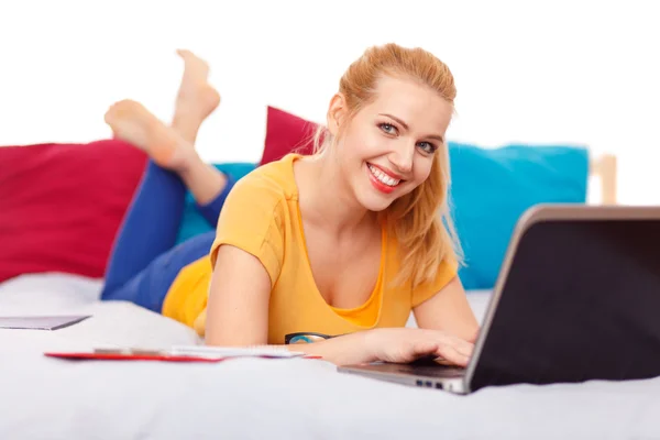 Jonge vrouw met haar laptop in bed — Stockfoto