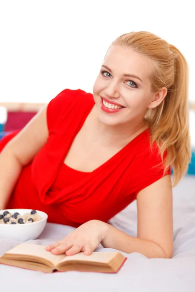 Young woman reading a book in bed Royalty Free Stock Photos