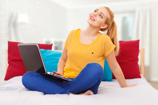 Jovem com seu laptop na cama — Fotografia de Stock