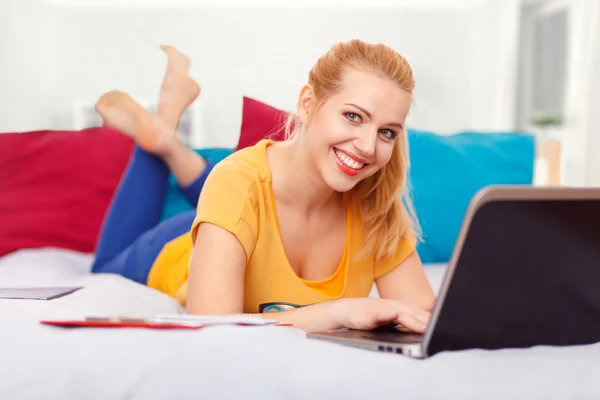 Junge Frau mit ihrem Laptop im Bett — Stockfoto