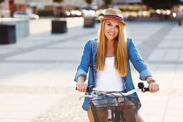 Jonge mooie vrouw in een fiets in de stad — Stockfoto