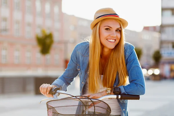 Ung vacker kvinna i en cykel i staden — Stockfoto