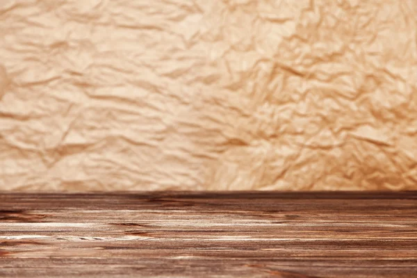 Fondo de papel arrugado y superficie de mesa de madera — Foto de Stock