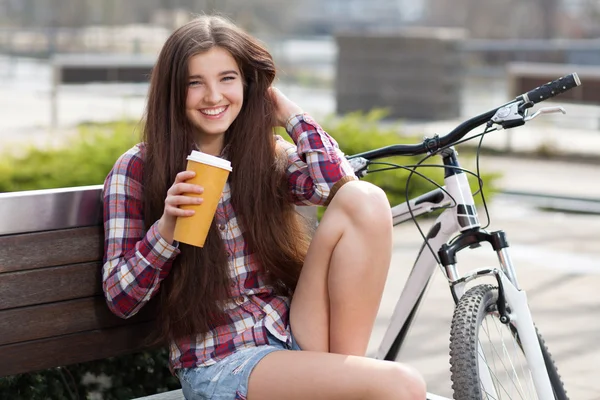 Giovane donna che beve caffè in un viaggio in bicicletta — Foto Stock