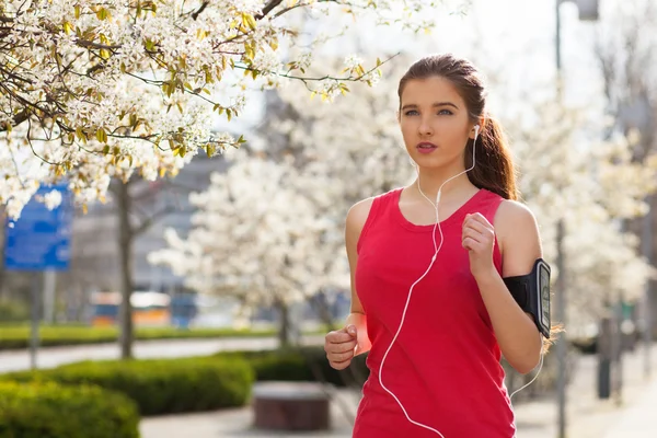 Young beautiful woman running in the city — Stock Photo, Image